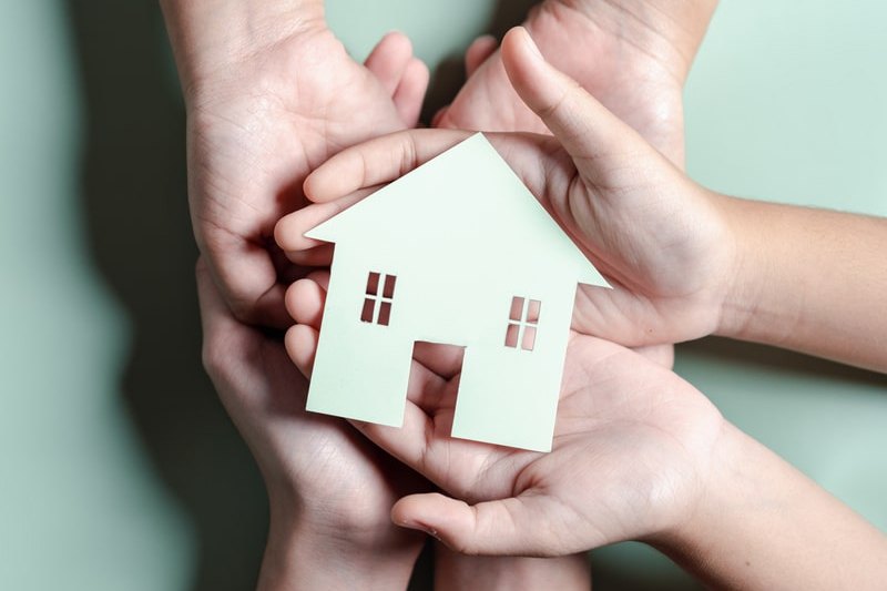 Hands cradling a house